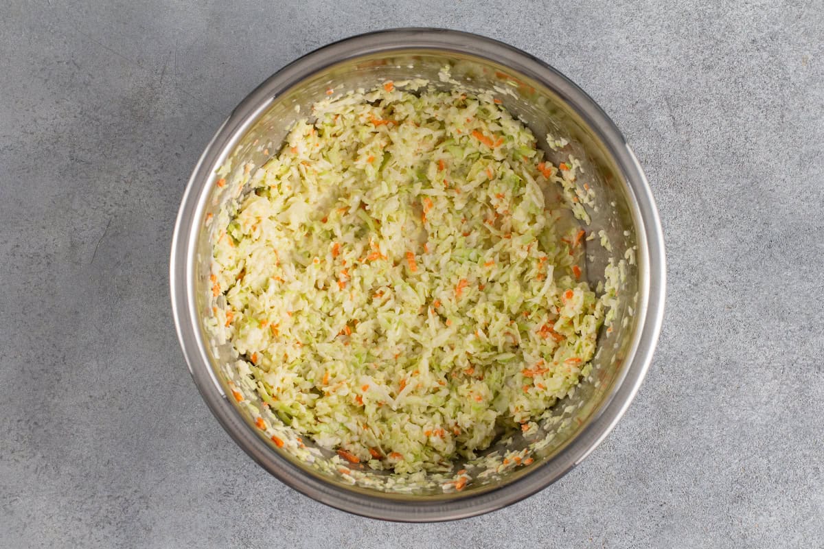 KFC coleslaw tossed with dressing in a bowl before chilling
