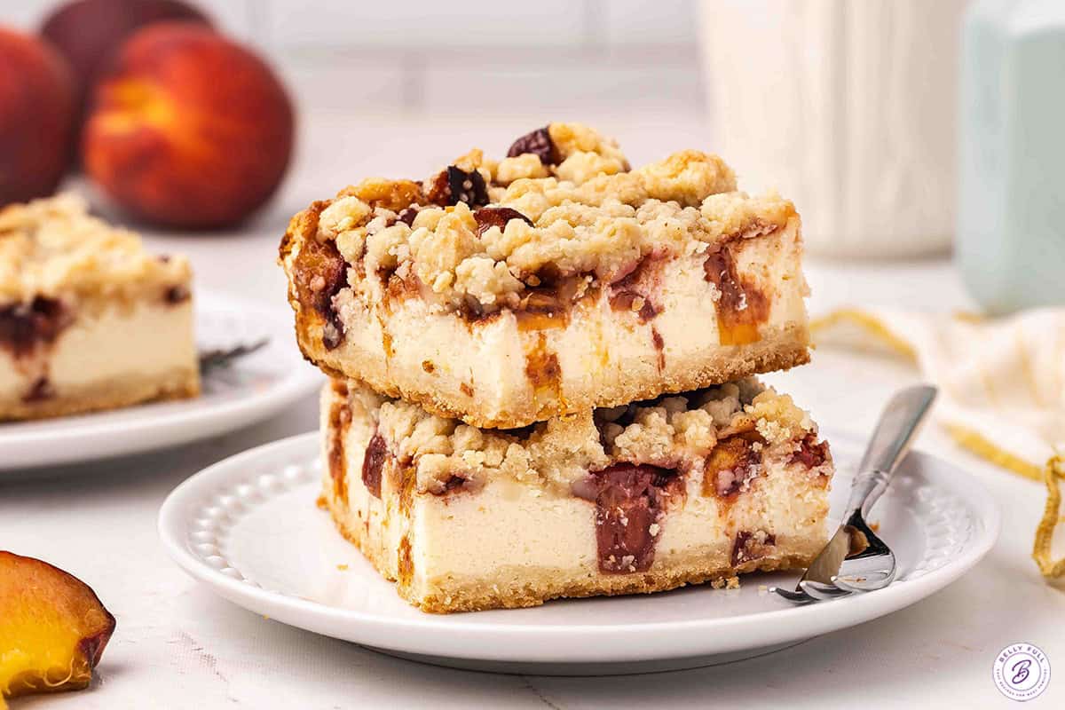 Side view of a plate of peach cobbler cheesecake bars.