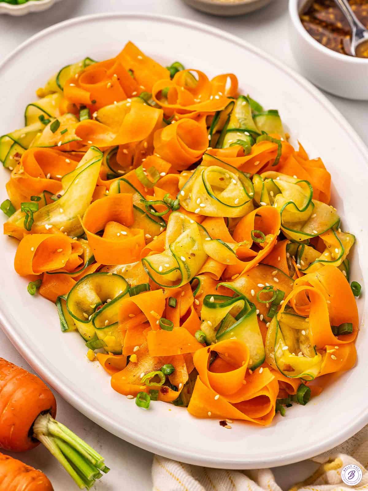 Overhead view of a platter of shaved carrot salad.