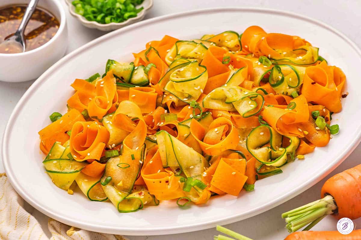 Side view of a shaved carrot salad on a platter.