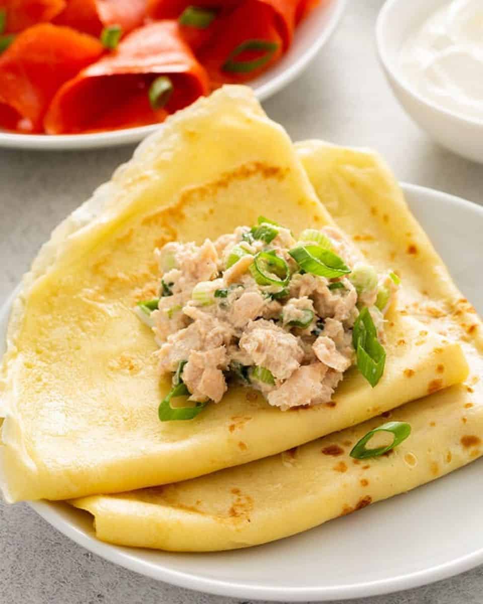 Folded blini filled with tuna salad and scallions, served with sour cream and smoked salmon on the side