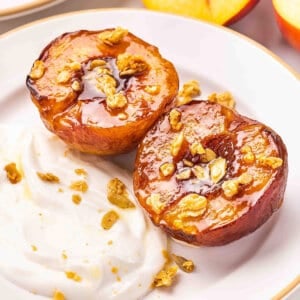 Air fryer peaches on a plate with yogurt and granola.