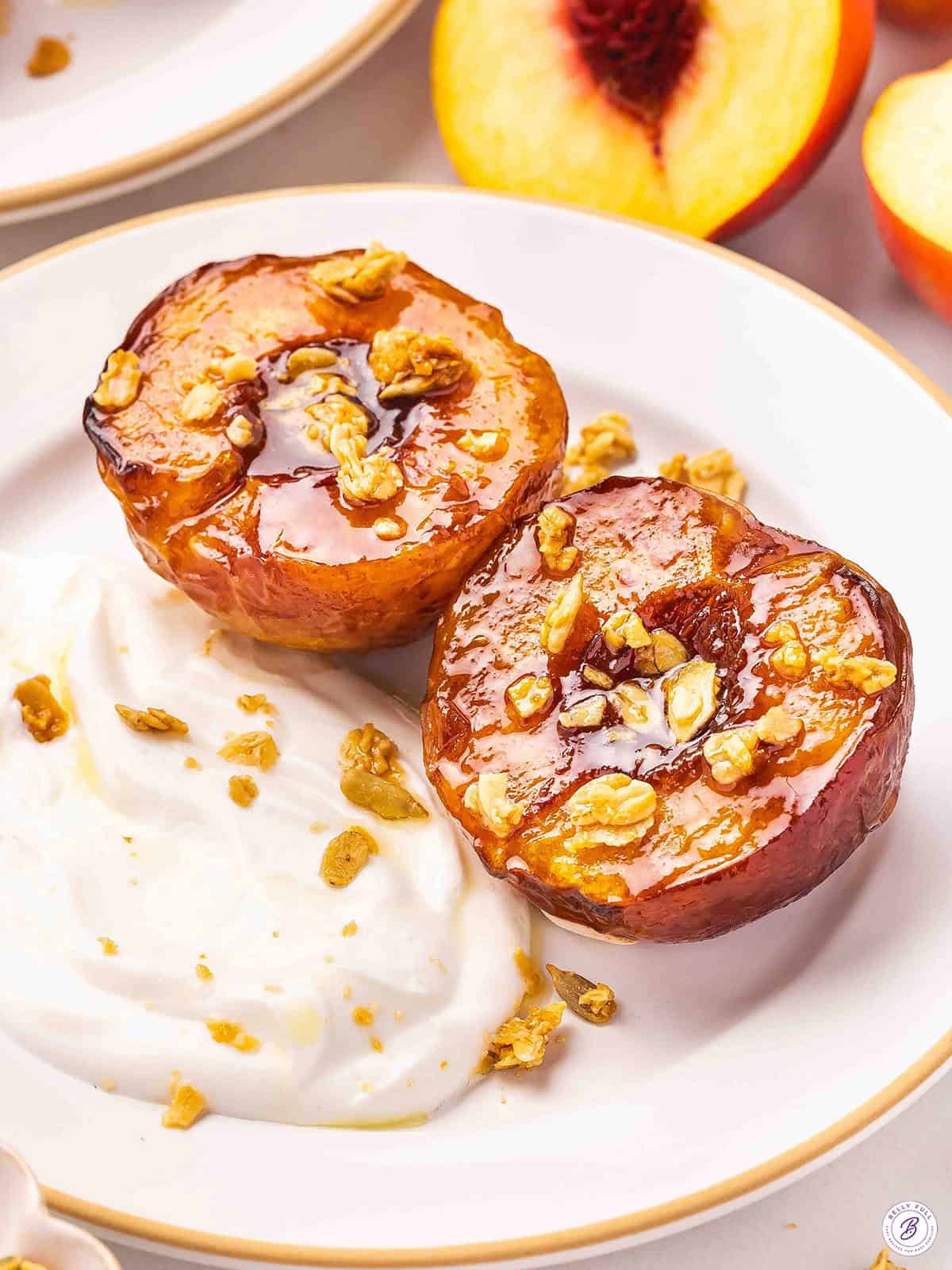 Air fryer peaches on a plate with yogurt and granola.
