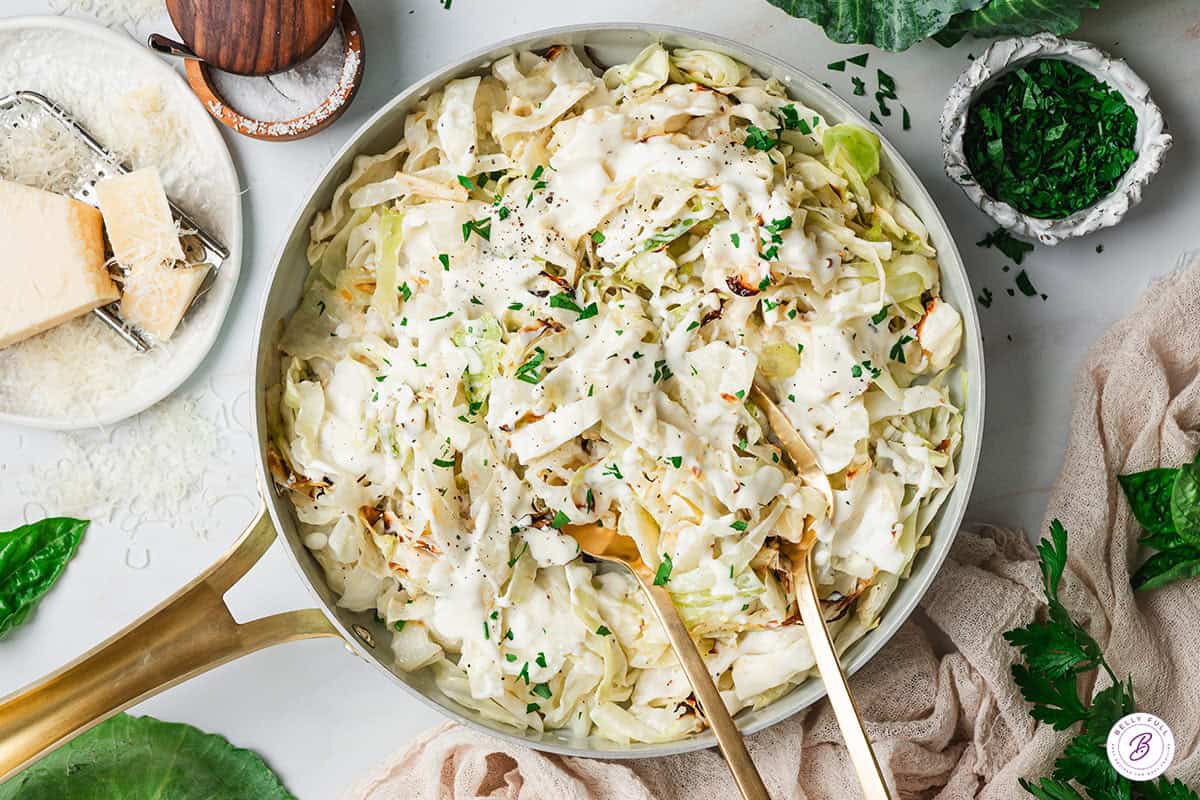 Overhead view of alfredo cabbage ribbons in a skillet.