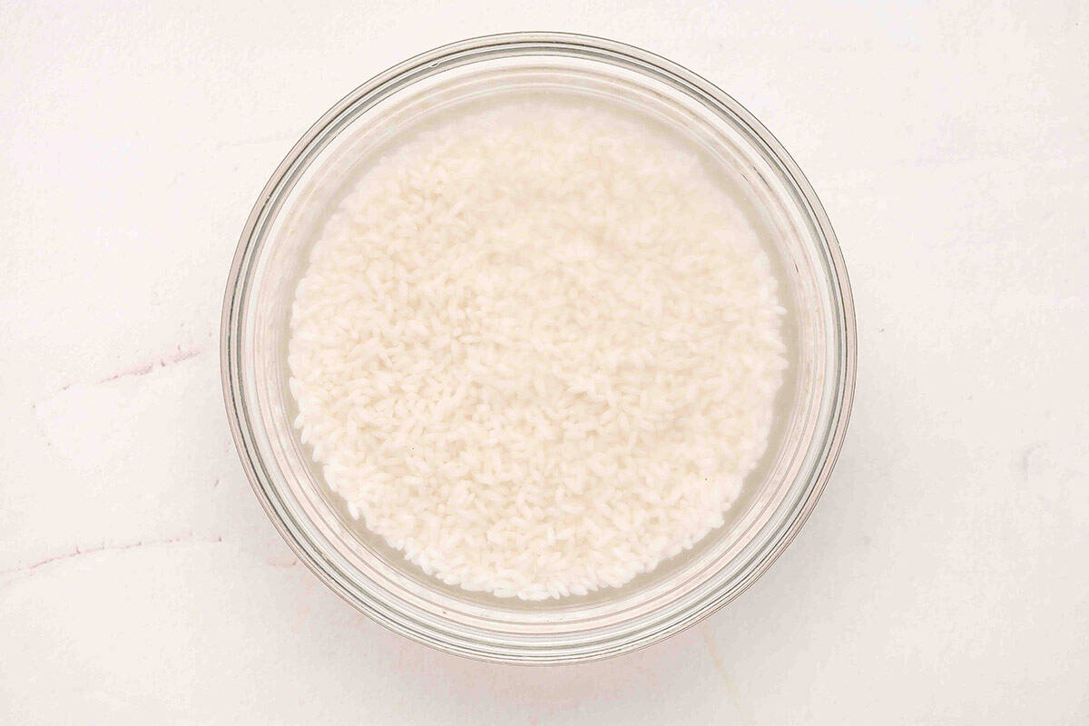 Thai rice soaking in a bowl of water.