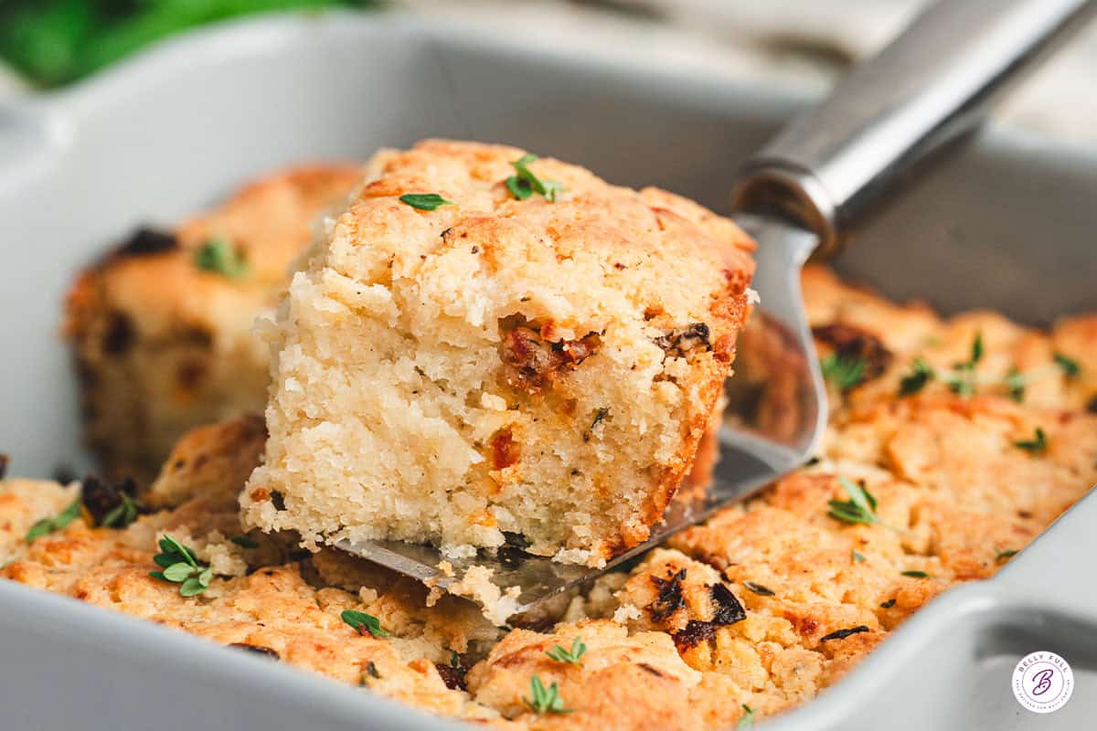 A Marry Me butter swim biscuit being lifted out of the baking dish