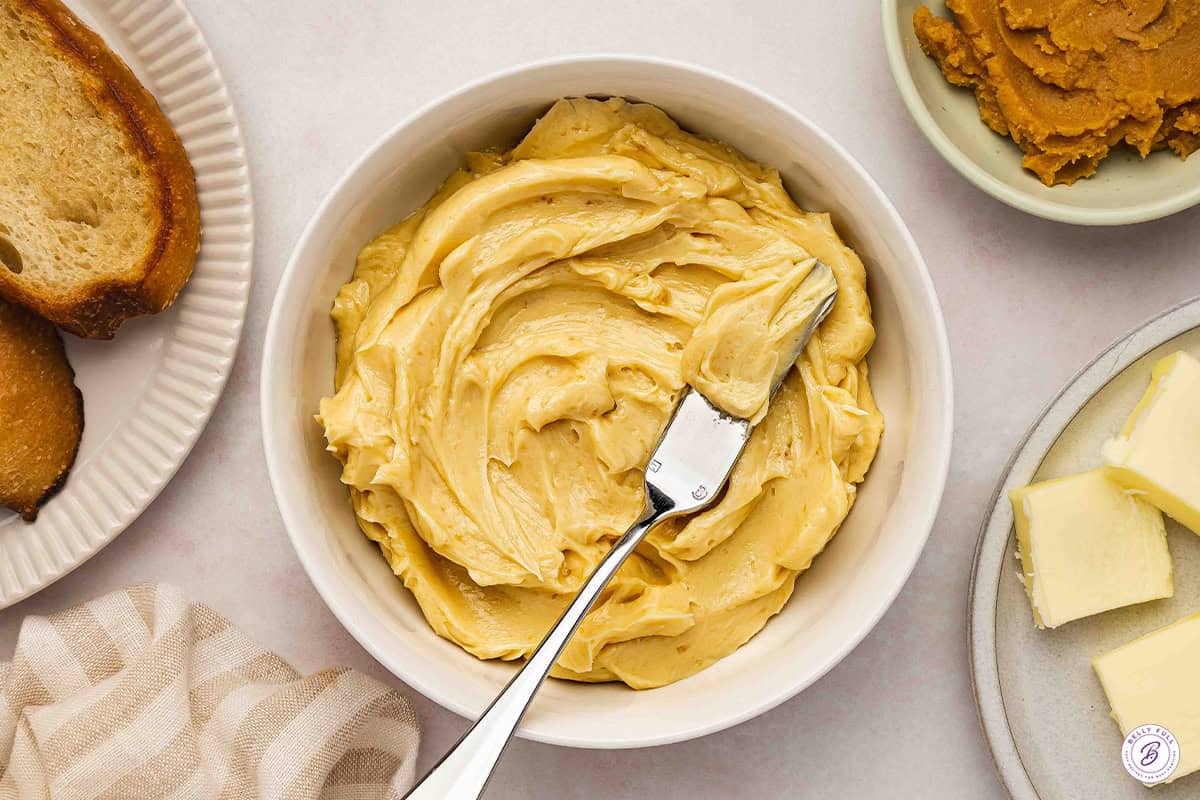Overhead view of a bowl of miso butter with a knife.