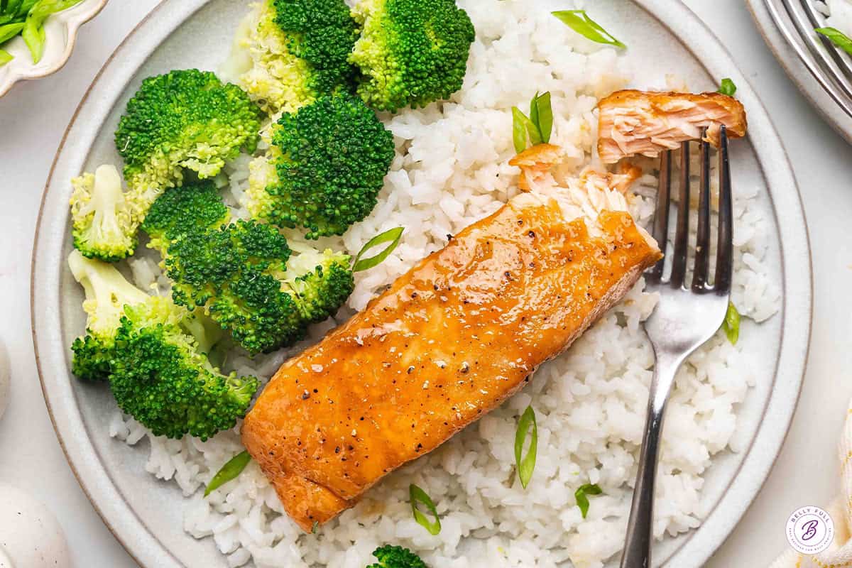 Overhead view of brown sugar glazed salmon on a plate with white rice and broccoli.